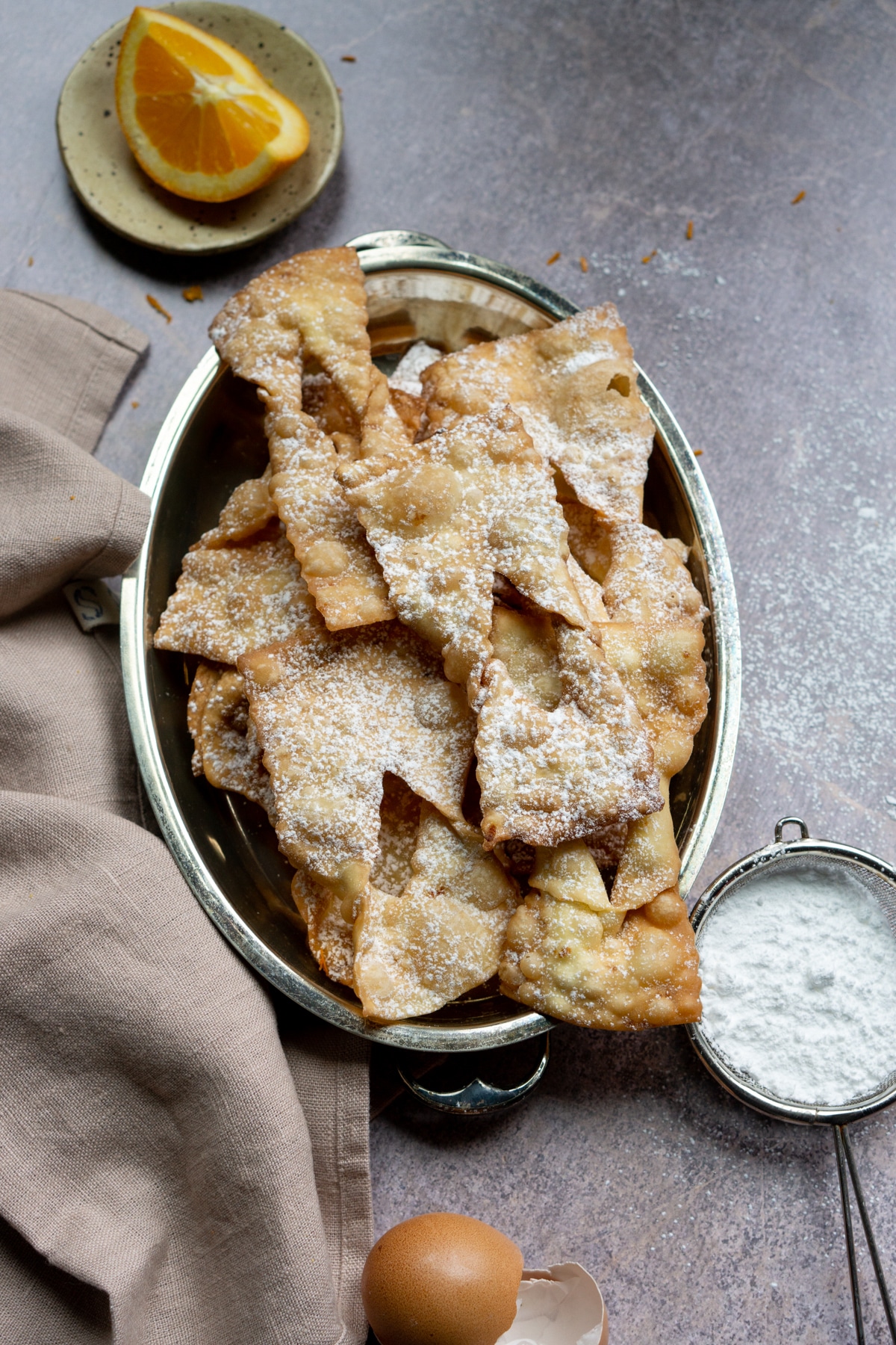 Chiacchiere in a serving tray with a napkin to the side