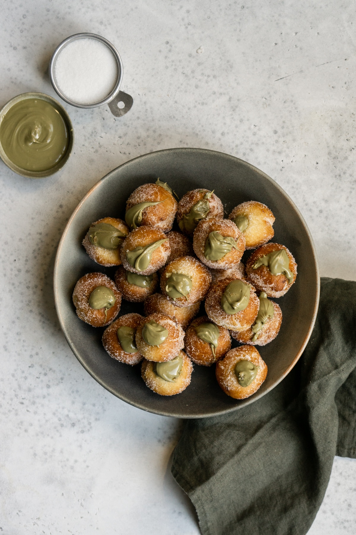Plate of pistachio castagnole with a green napkin to the side
