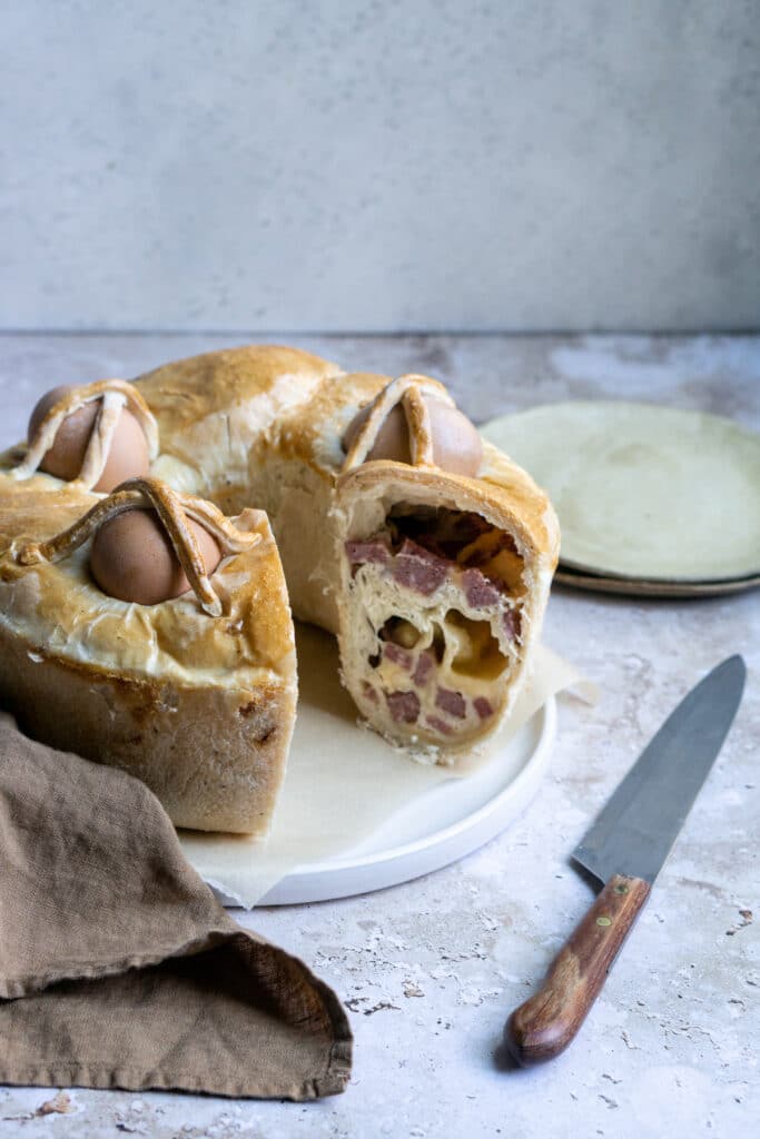Casatiello - stuffed Italian Easter bread on a plate with a knife to the side