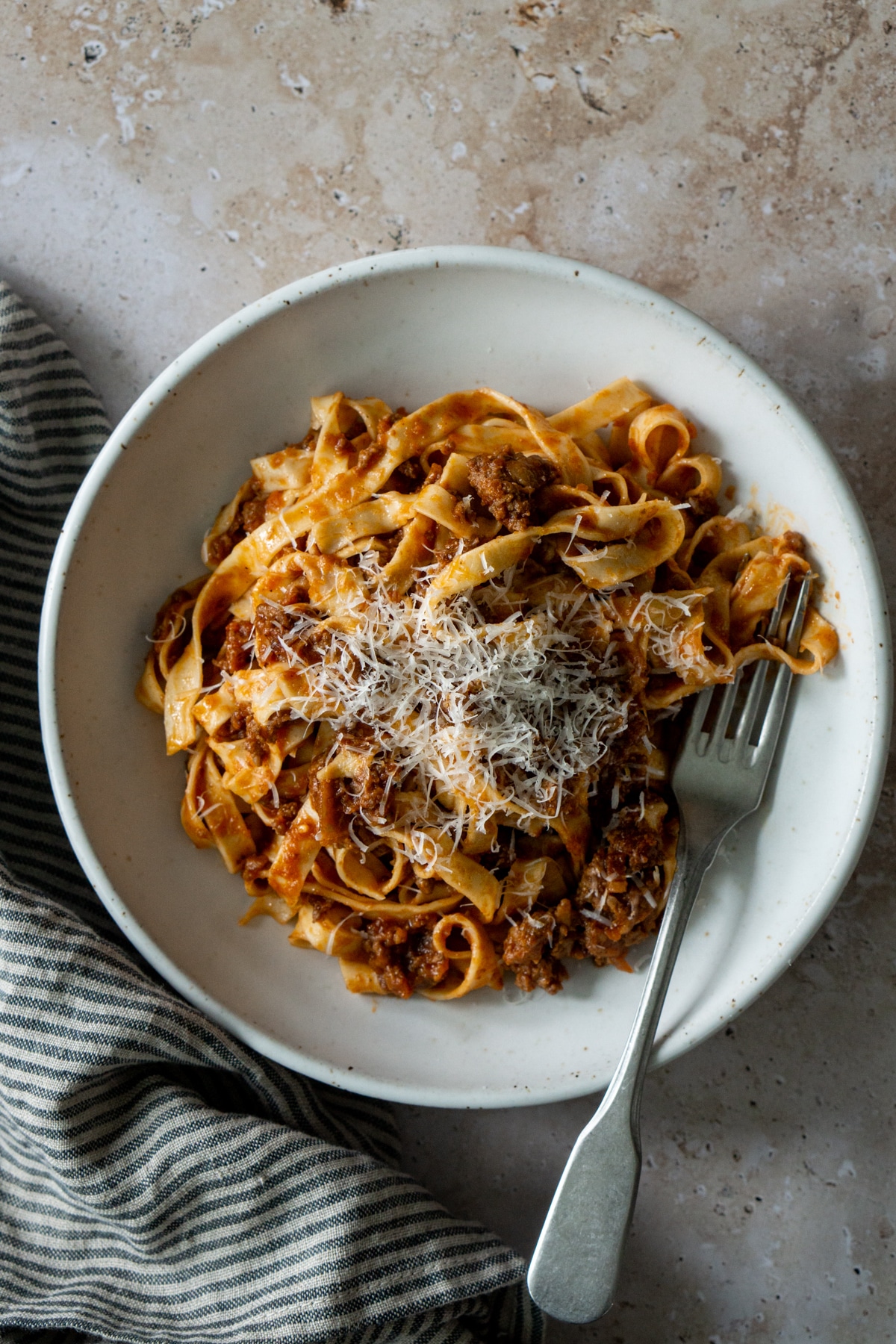 Tagliatelle alla bolognese in a plate with a napkin to the side