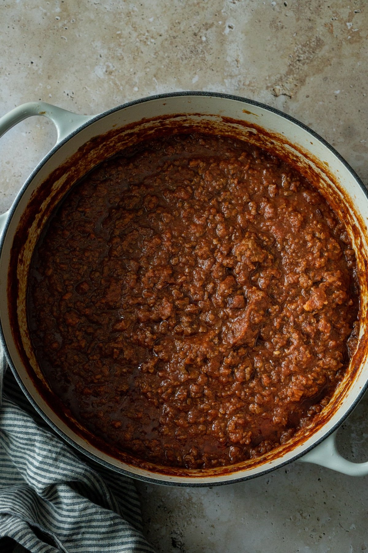 Bolognese sauce in a pot with a napkin to the side