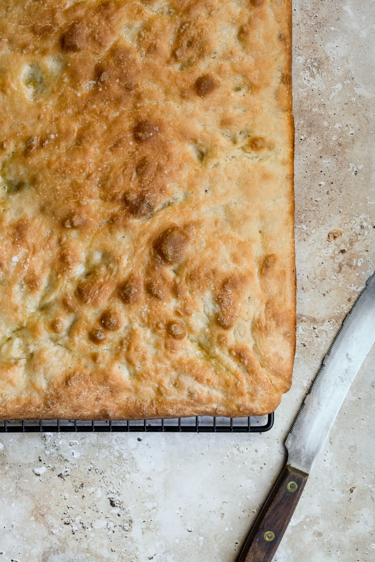 Schiacciata on a cooling rack with a knife to the side