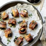 Stuffed prunes in a dish topped with fresh thyme