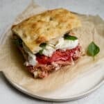 Prosciutto panino with mozzarella, tomato and basil on a plate