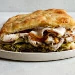Porchetta panino with gorgonzola and pistachio pesto on a plate