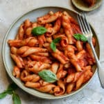 Nduja pasta in a bowl topped with fresh basil