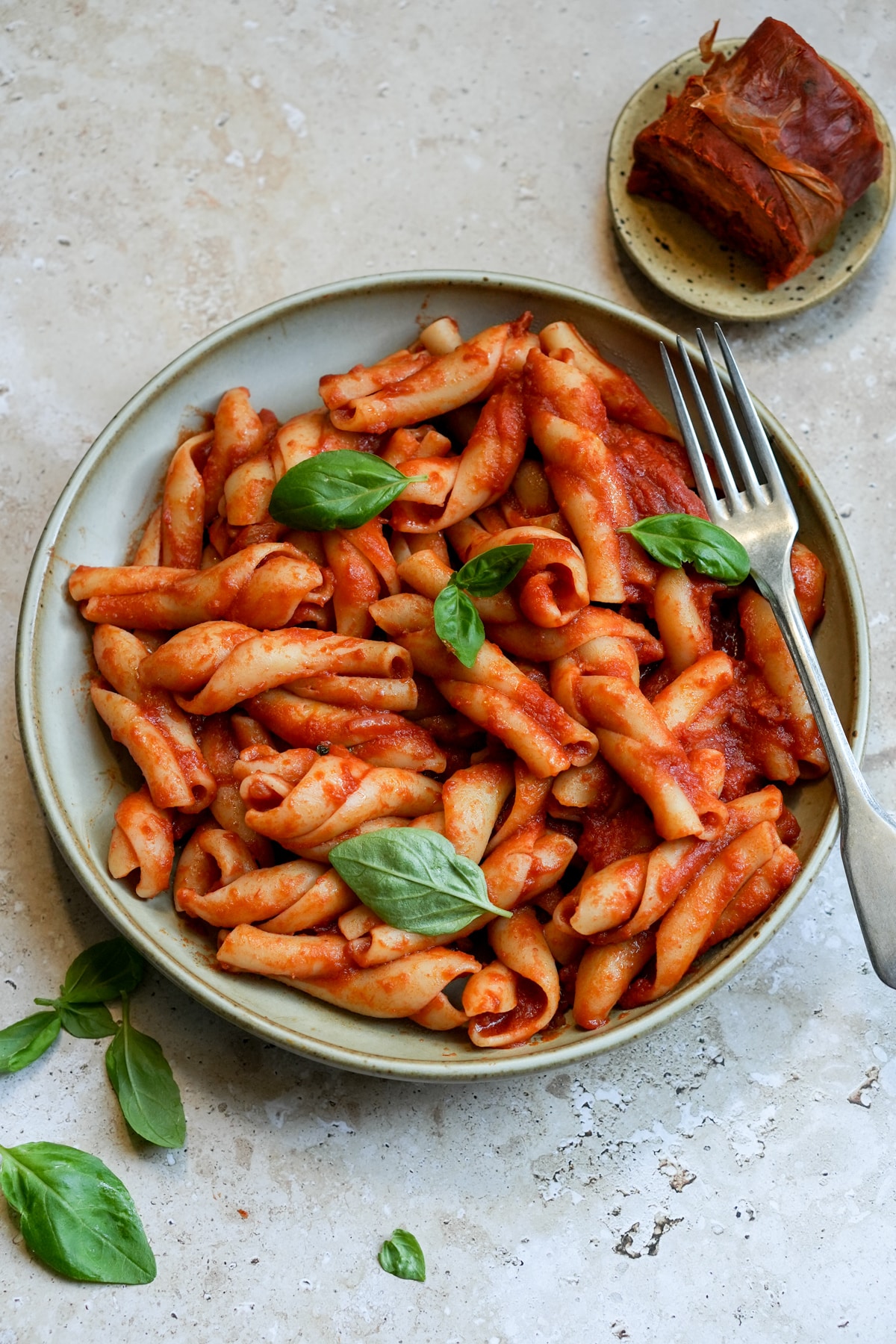 Nduja pasta in a bowl topped with fresh basil