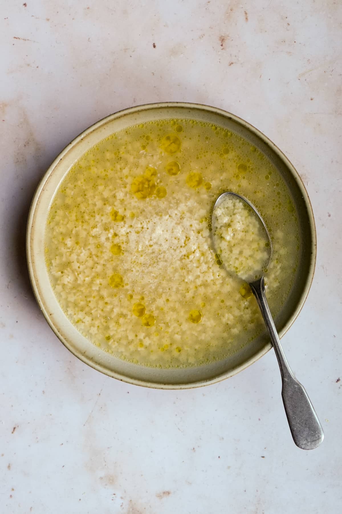 chicken pastina soup in a bowl with a spoon