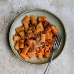 Spicy sausage pasta in a bowl with a fork to the side