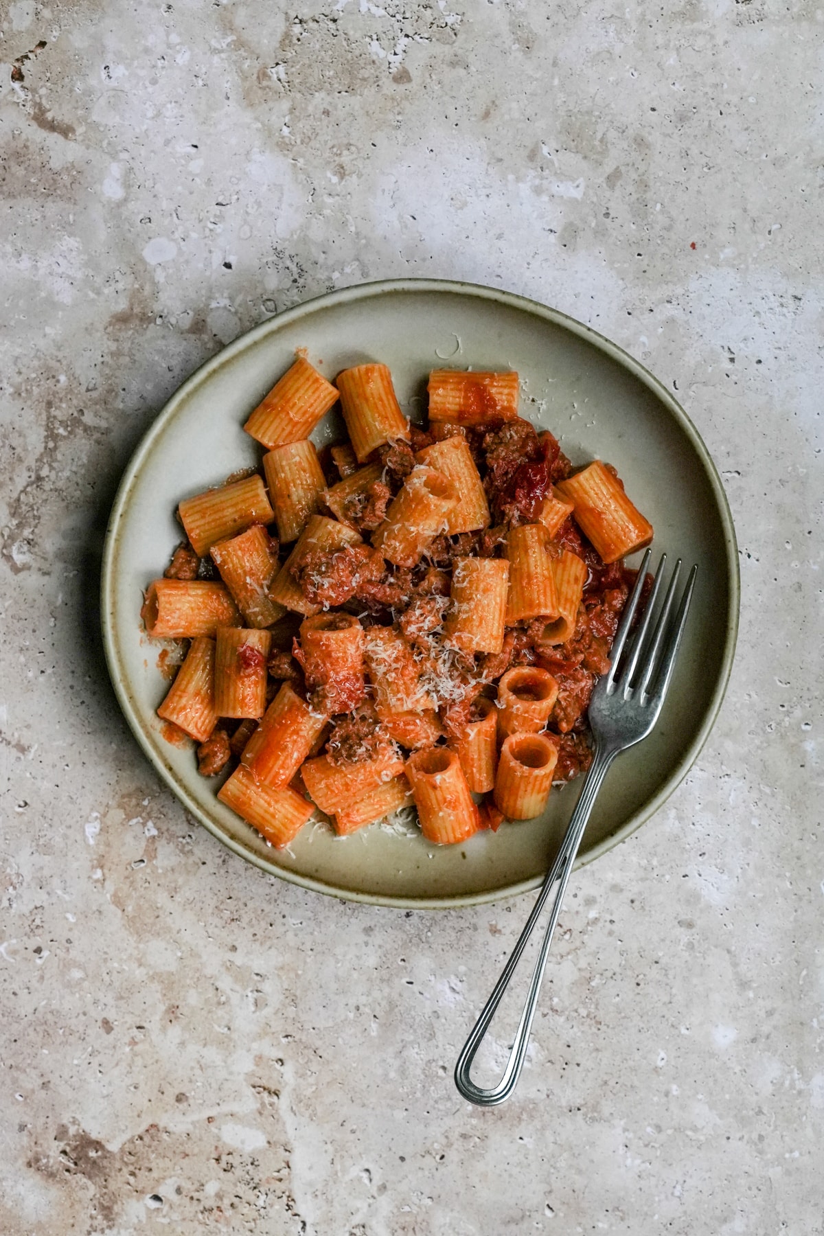 Spicy sausage pasta in a bowl with a fork