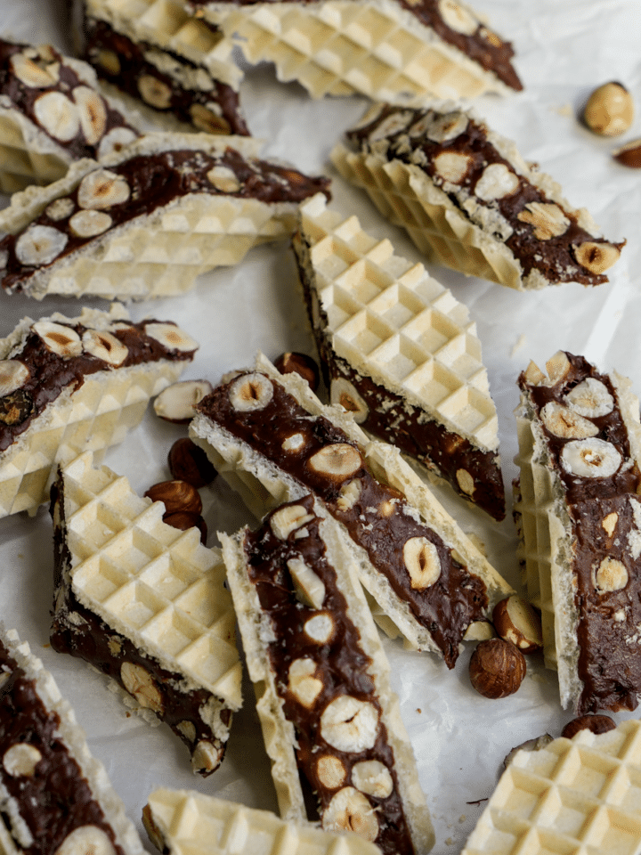Pieces of chocolate marshmallow torrone with hazelnuts on a piece of parchment paper