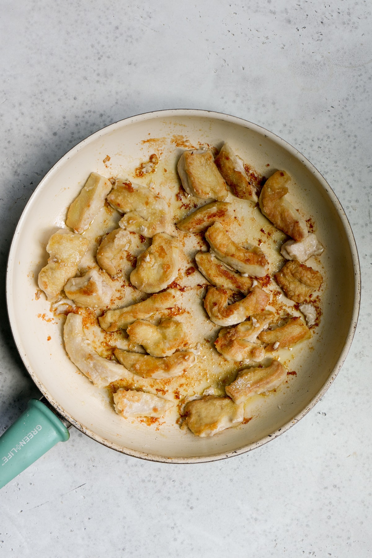 Process photo - browned chicken breast in olive oil in a skillet