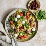 Arugula pasta salad in a bowl with two forks