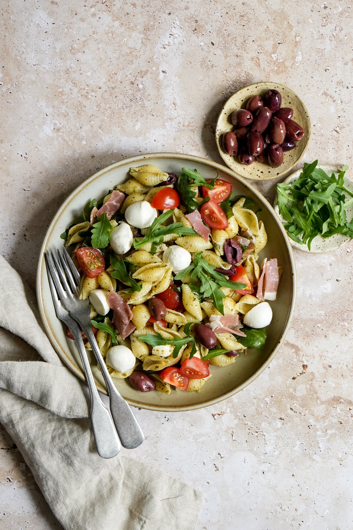 Arugula pasta salad in a bowl with two forks