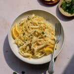 Creamy lemon pasta in a bowl garnished with fresh lemons