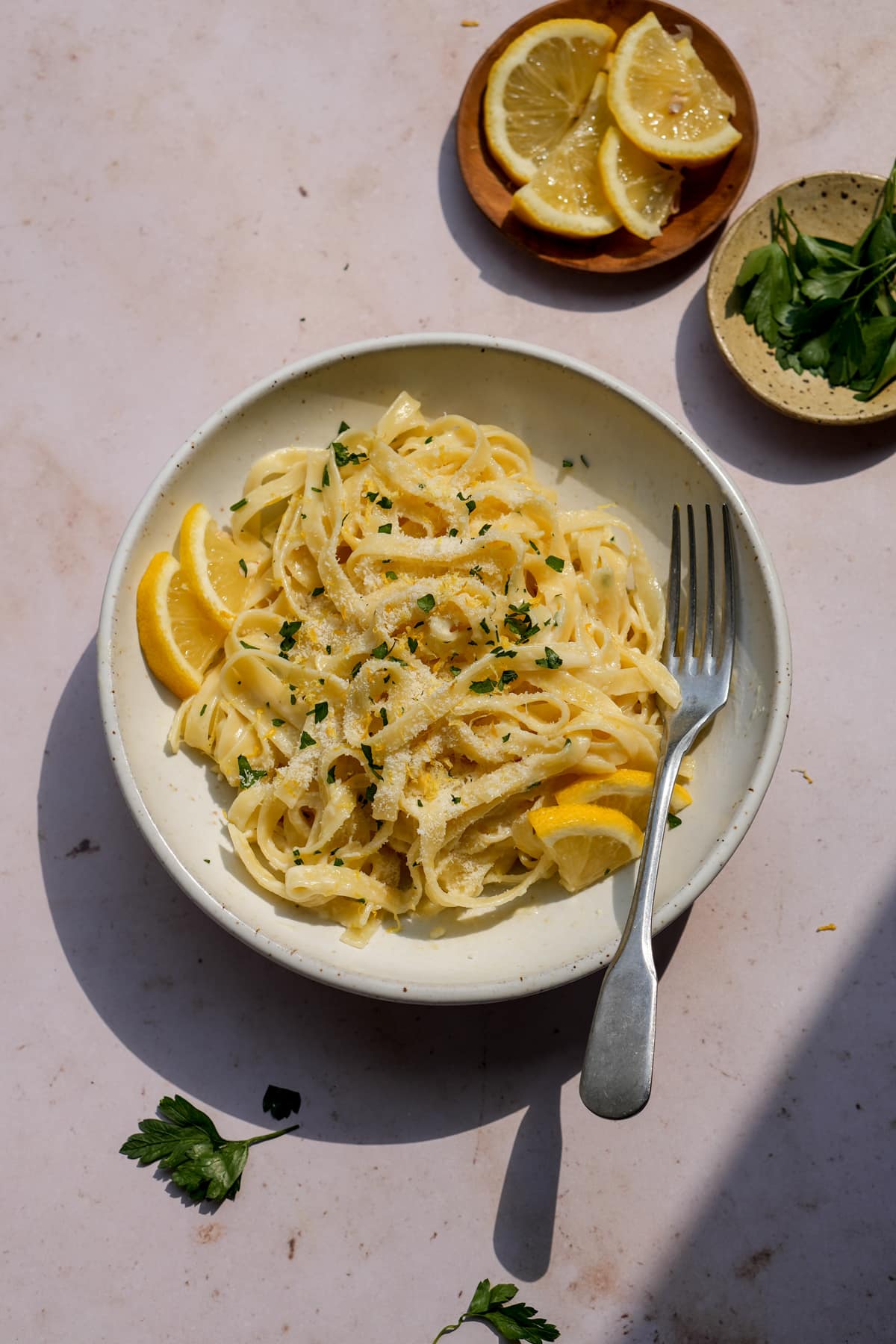 Creamy lemon pasta in a bowl garnished with fresh lemons