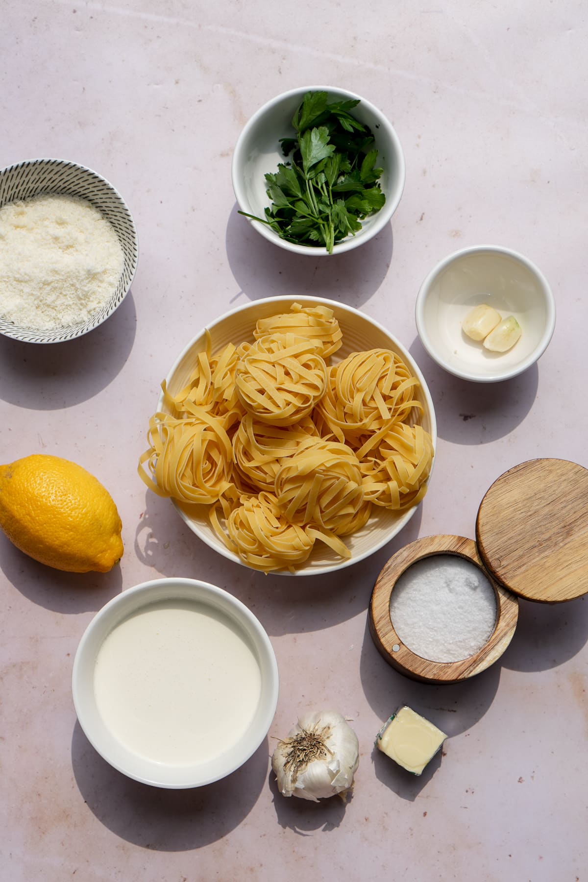 Creamy lemon pasta ingredients - tagliatelle, whipping cream, lemons, garlic, butter, salt, garlic, parsley, parmigiano reggiano