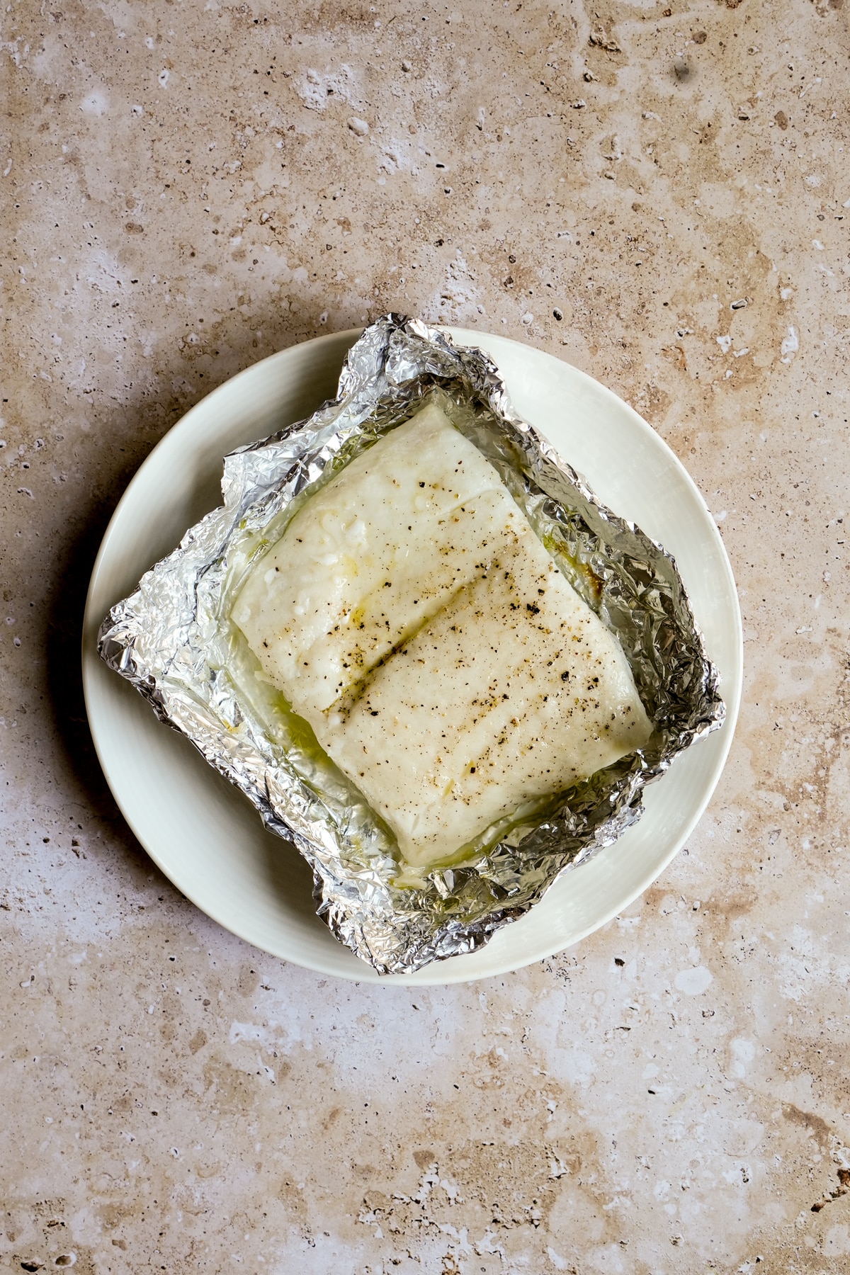 Grilled halibut in tin foil on a plate