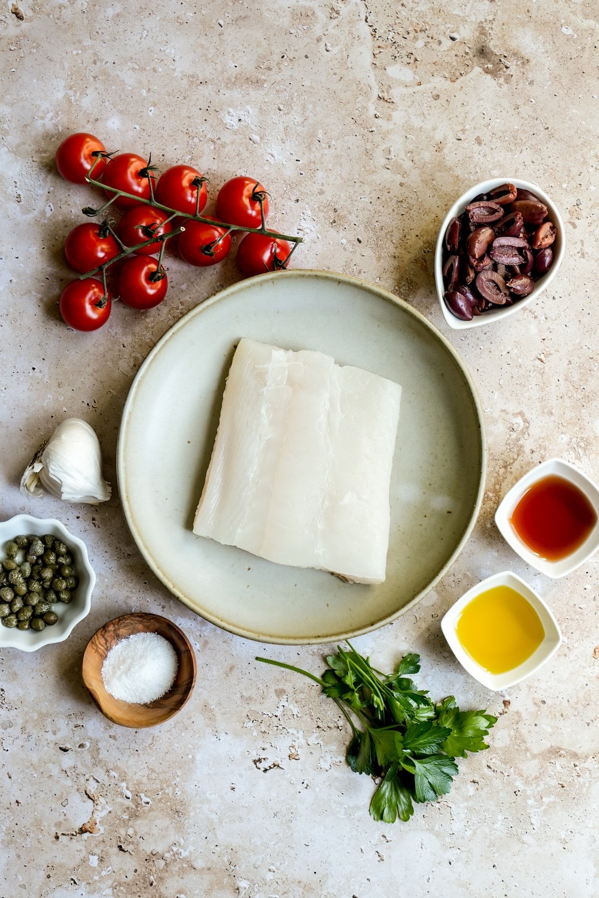 Italian halibut ingredients - halibut filet, olives, red wine vinegar, olive oil, parsley, salt, capers, garlic, tomatoes