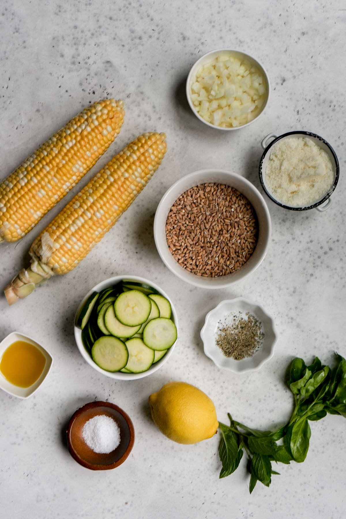 Italian farro salad ingredients - corn, farro, zucchini, onion, parmigiano, lemon, olive oil, salt, pepper, mint, basil