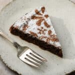 Piece of almond flour chocolate cake in a plate with a fork