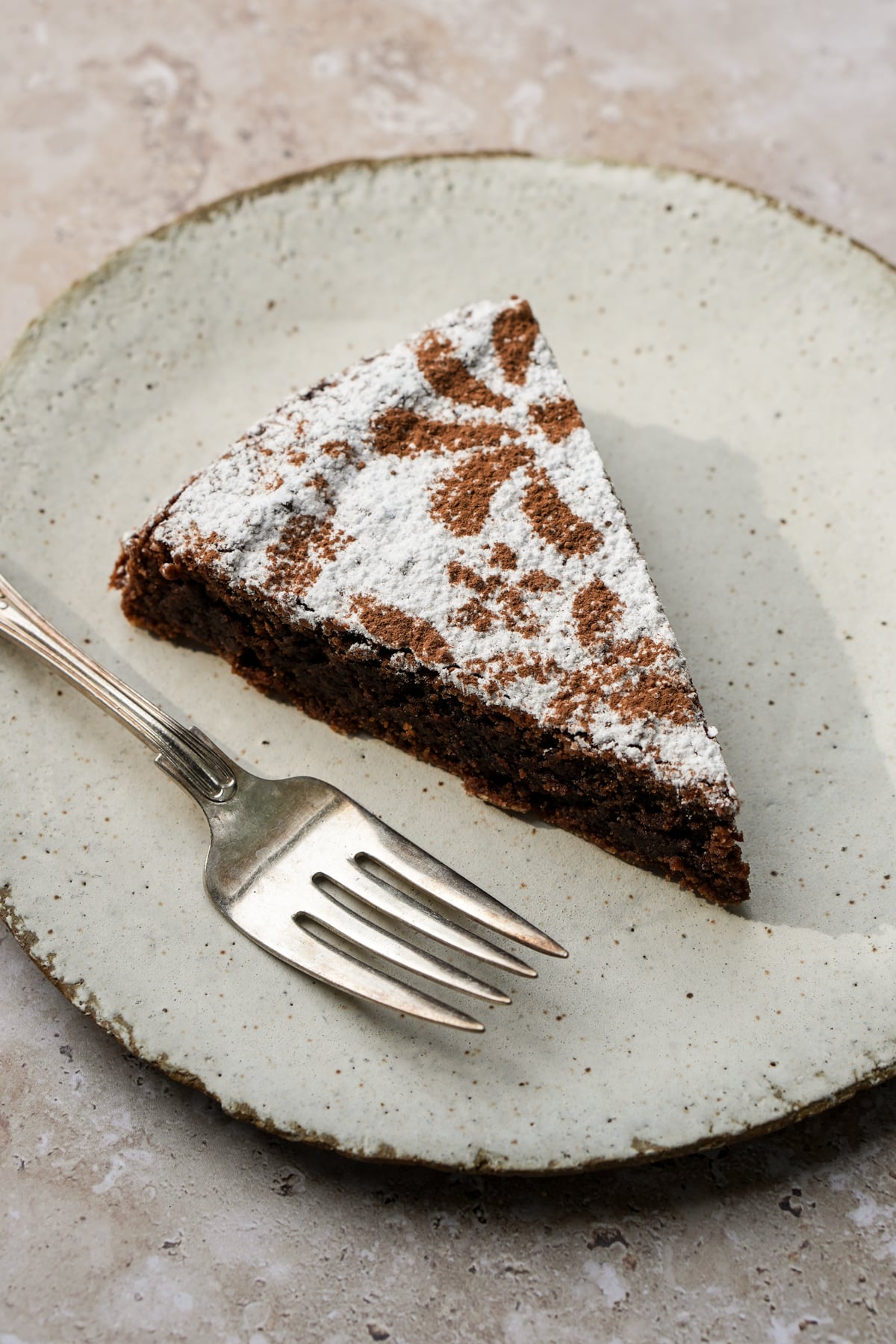 Piece of almond flour chocolate cake in a plate with a fork