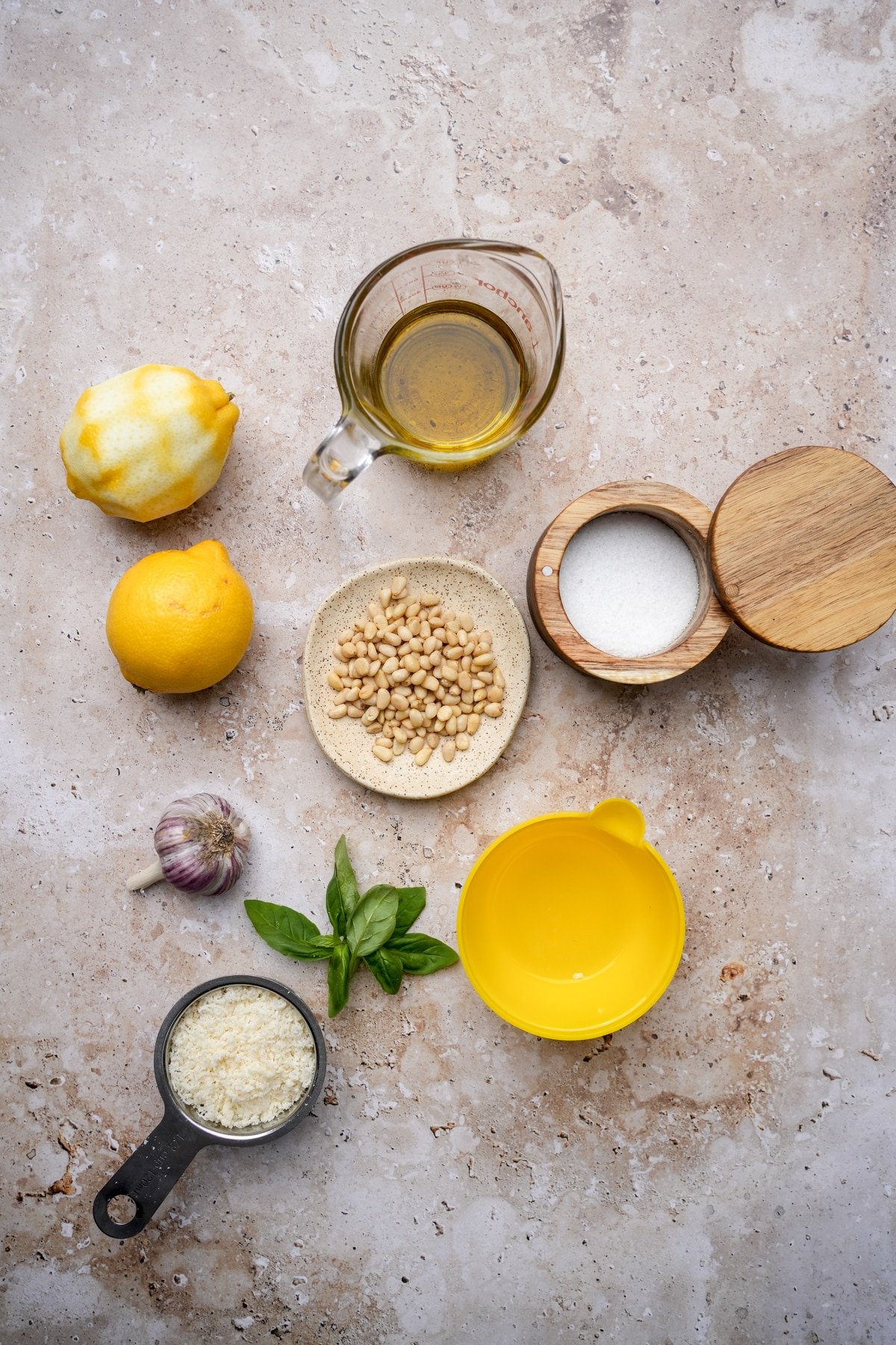 Lemon pesto ingredients - olive oil, salt, pine nuts, lemon juice, lemons, garlic, parmigiano, fresh basil, pine nuts