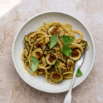 Spaghetti alla nerano in a dish with fried zucchini and fresh basil on top