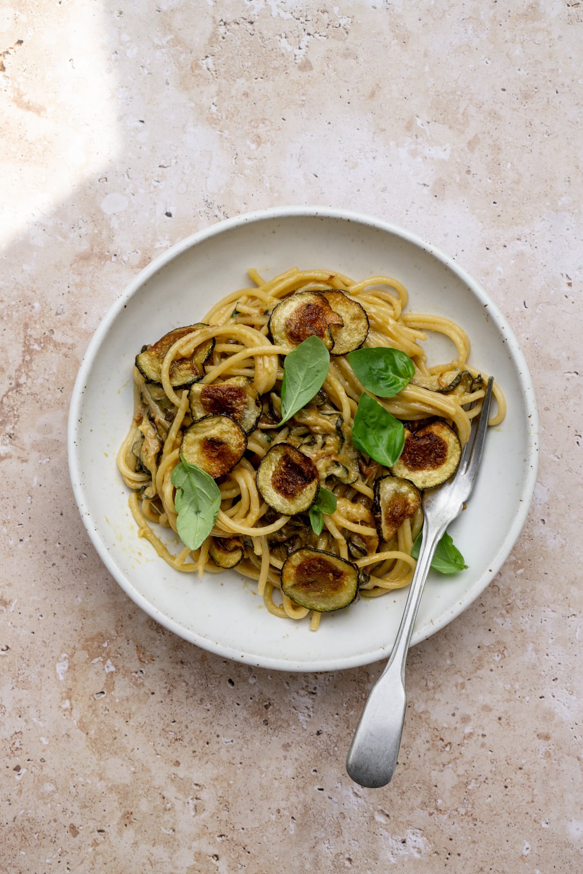 Spaghetti alla nerano in a dish with a fork to the side