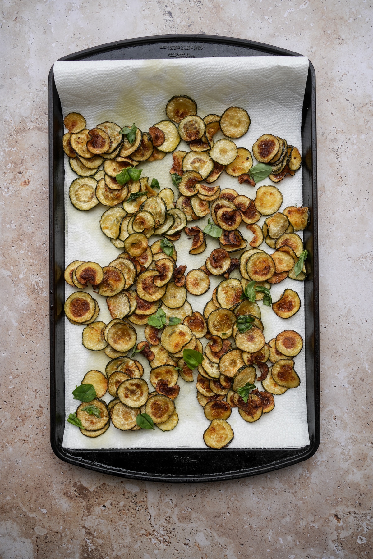 Fried zucchini in a pan lined with paper towels