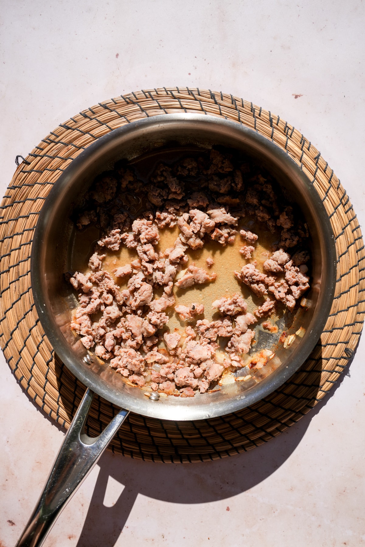 Cooked sausage and white wine in a pan