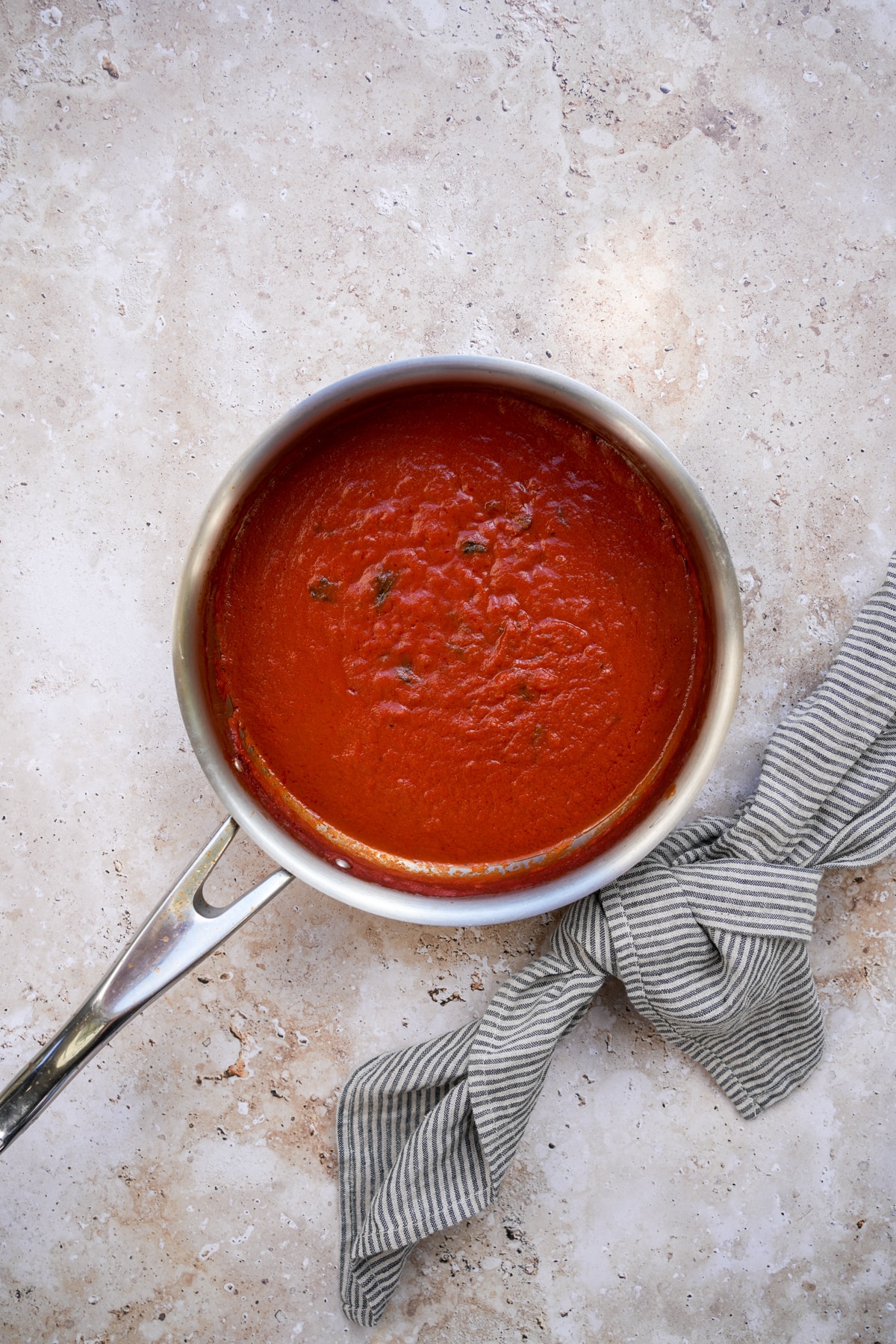 Tomato sauce in a pan with a napkin to the side