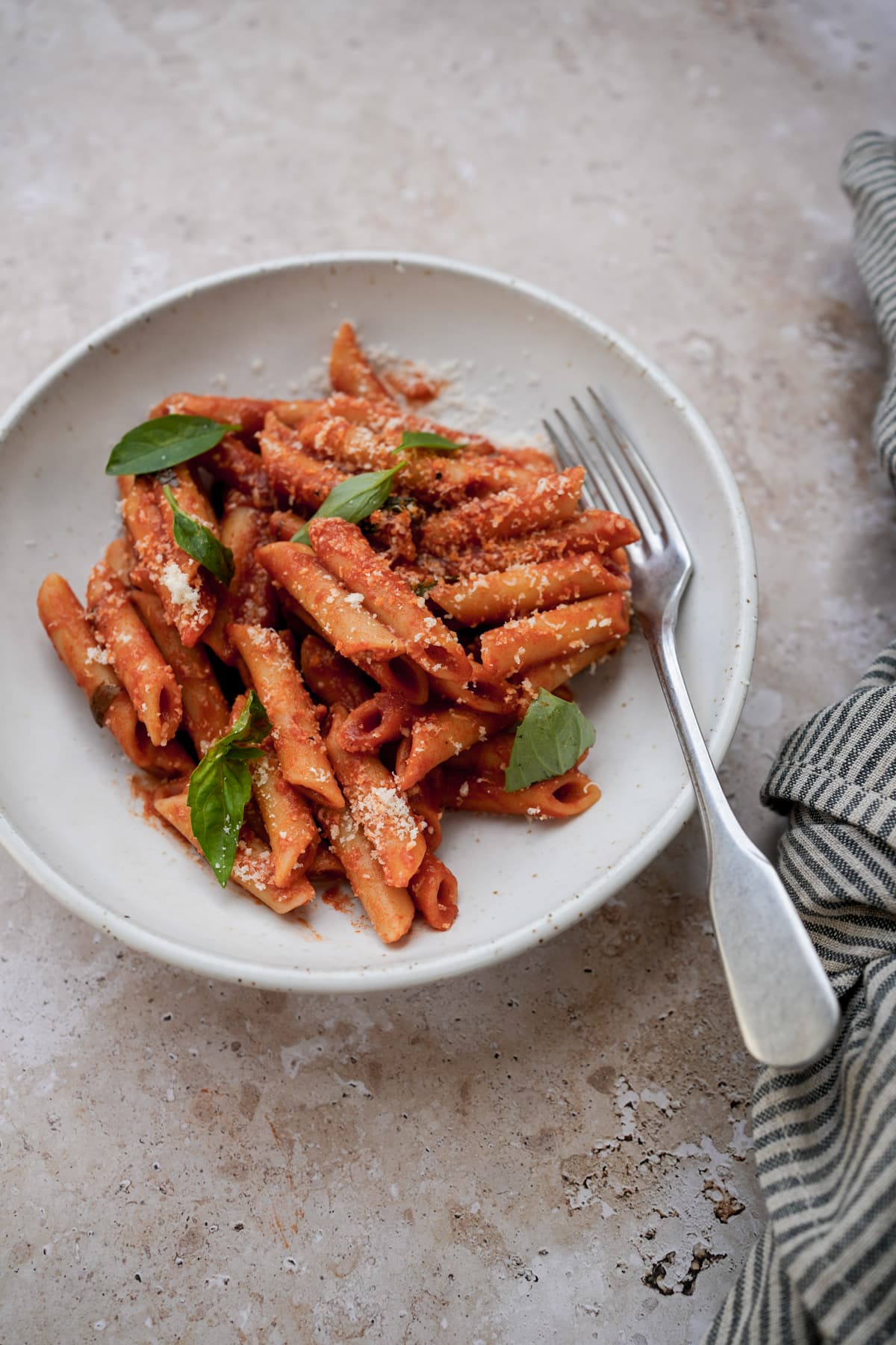 Bowl of penne pomodoro with a fork to the side