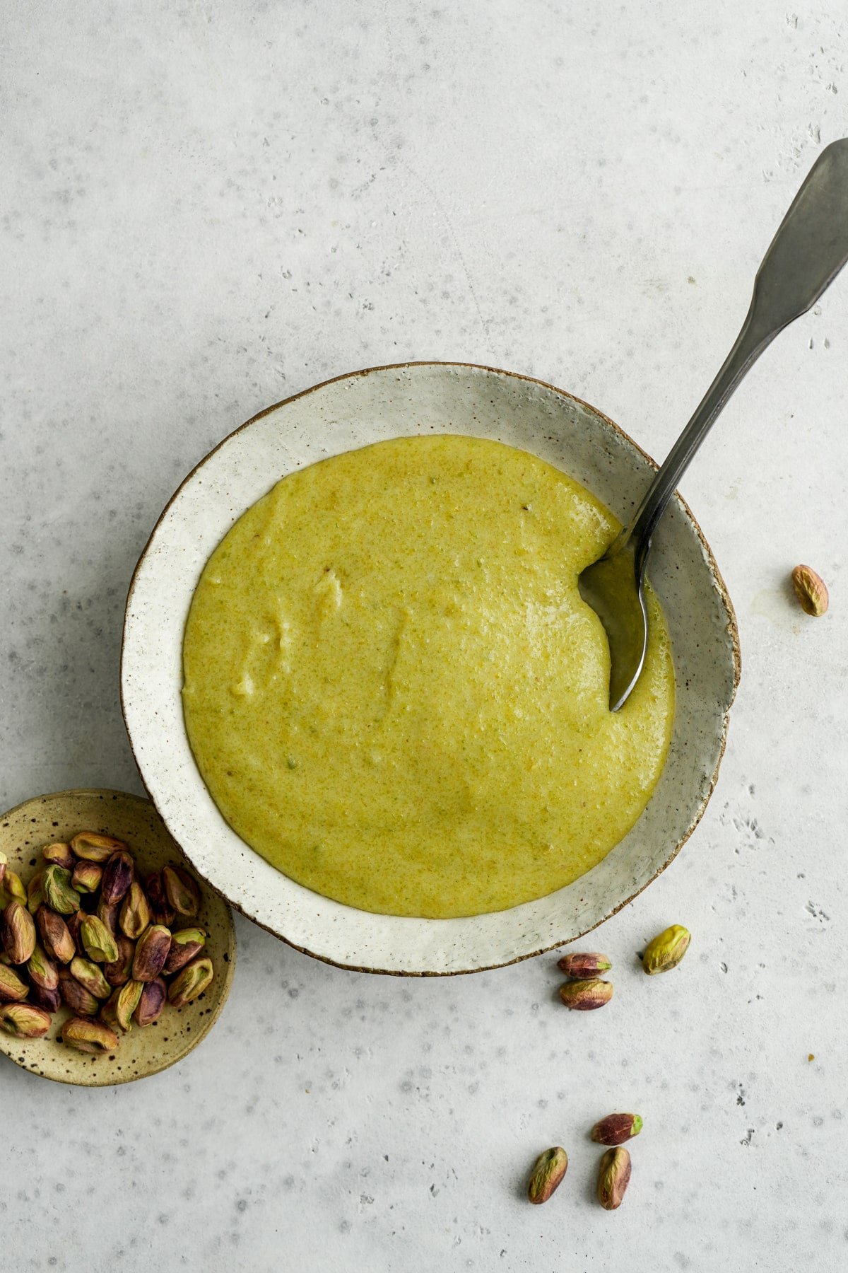 Bowl of pistachio cream with little dish of pistachios to the side