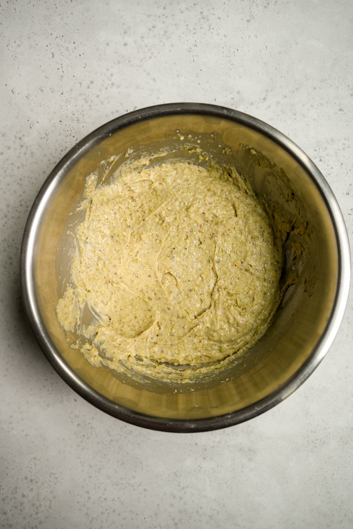 Pistachio muffin mixture in stainless steel bowl