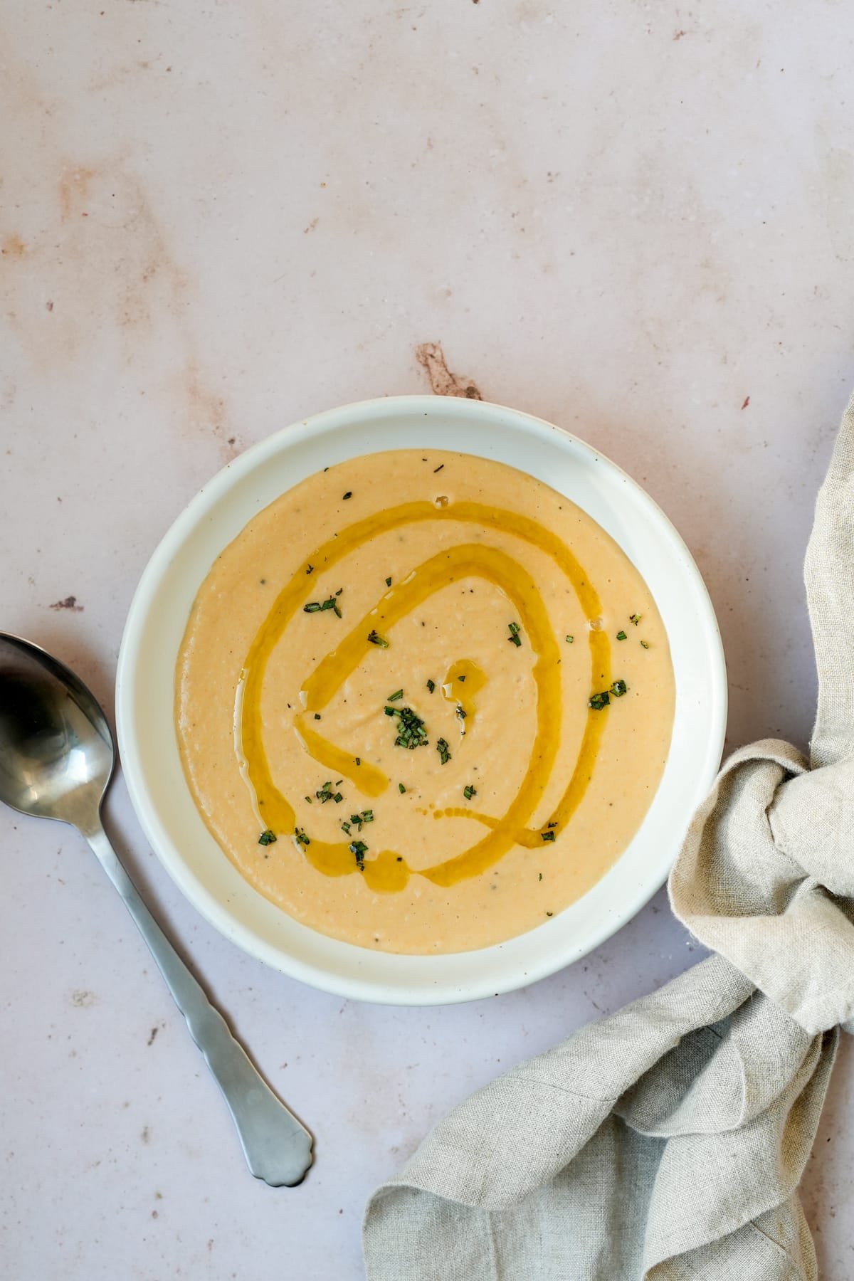 Italian white bean soup in a bowl topped with olive oil and chopped rosemary