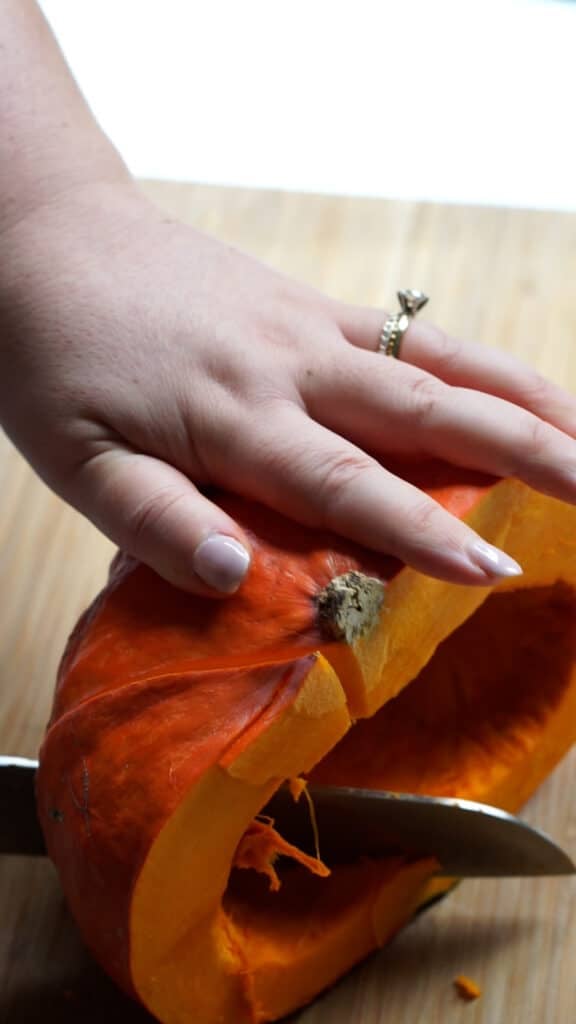 Cutting pumpkin half into pieces