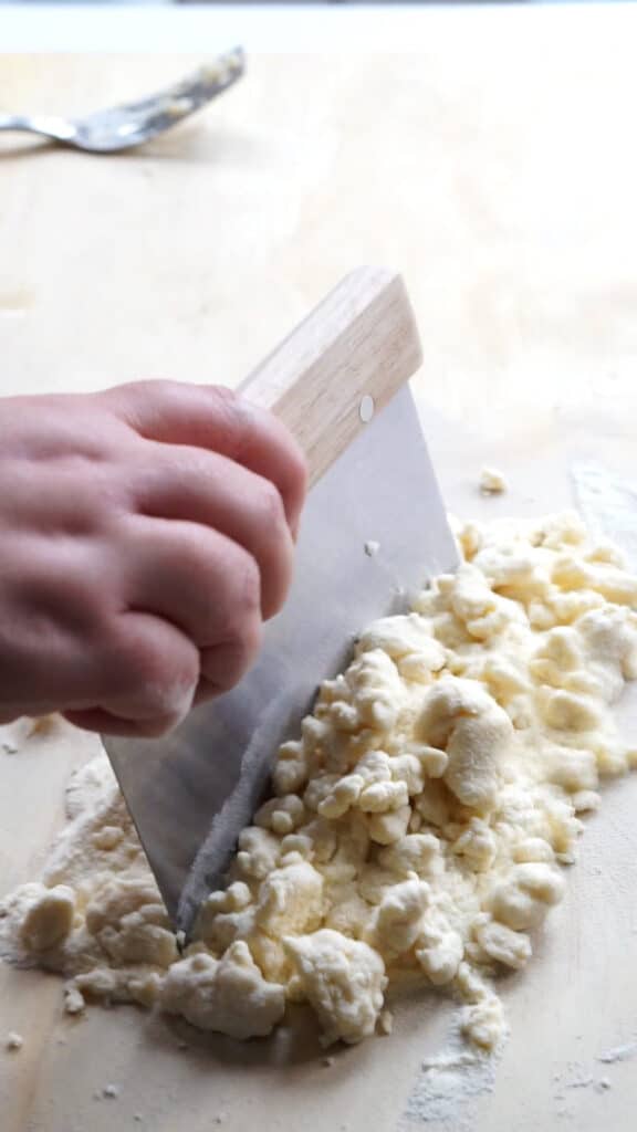 Semola rimacinata and water being mixed together with a bench scraper