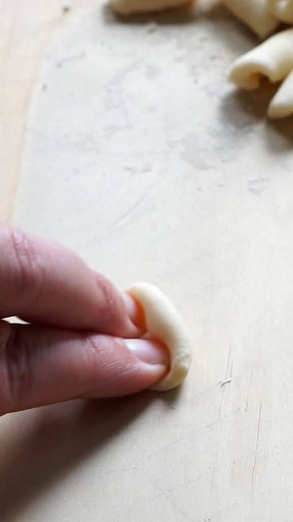 Cavatelli pasta being shaped with index and middle finger