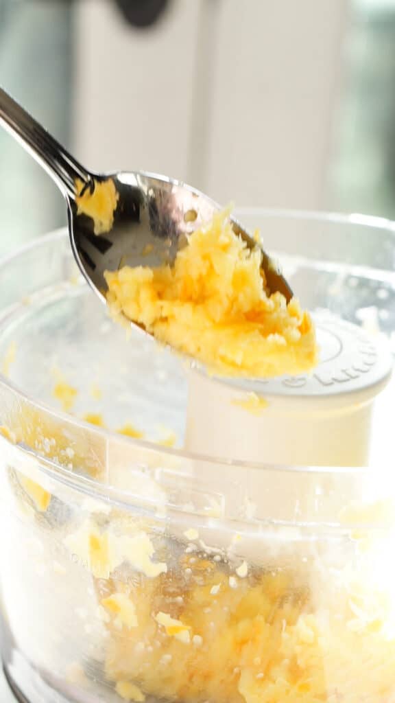 Pureed orange held up with a spoon for orange upside down cake