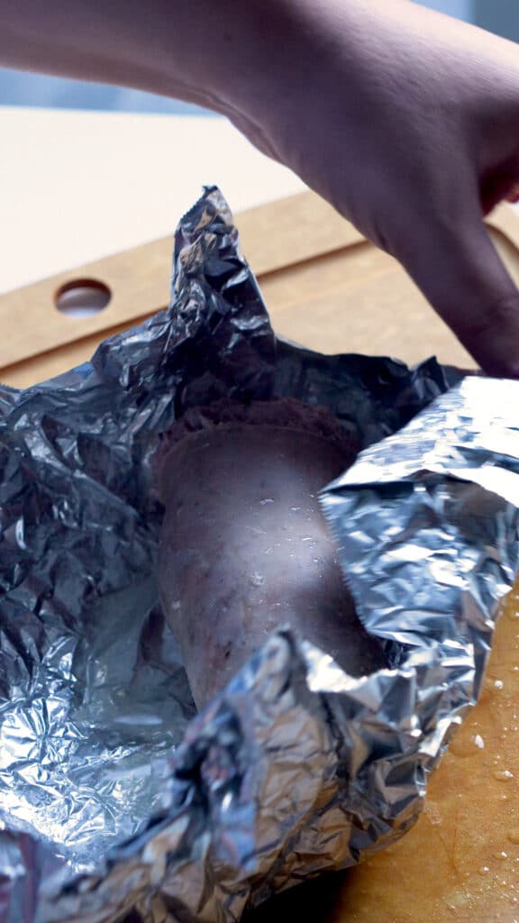 Cotechino removed from boiling water in tin foil