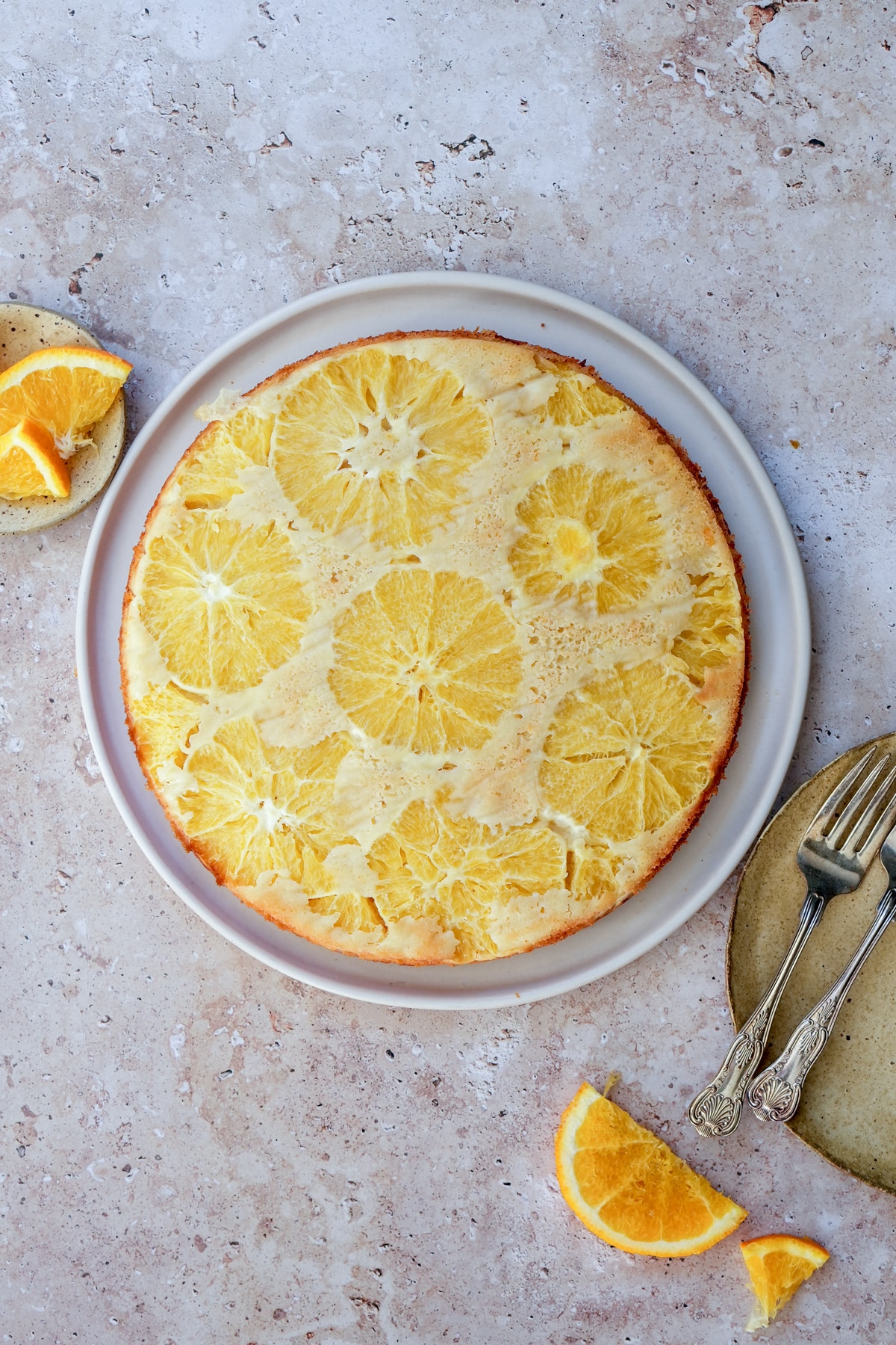 Orange upside down cake in a plate with forks to the side