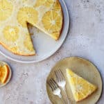 Orange upside down cake in a big plate with slice cut out