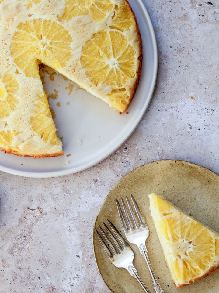 Orange upside down cake in a big plate with slice cut out