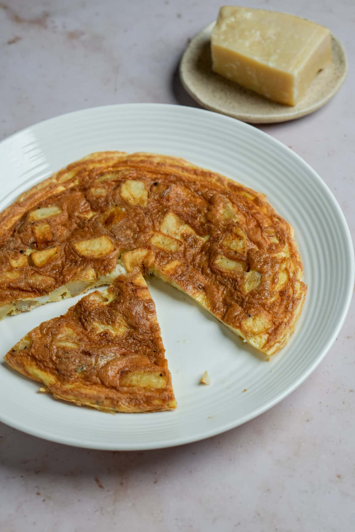 Potato frittata in a plate with a piece cut out