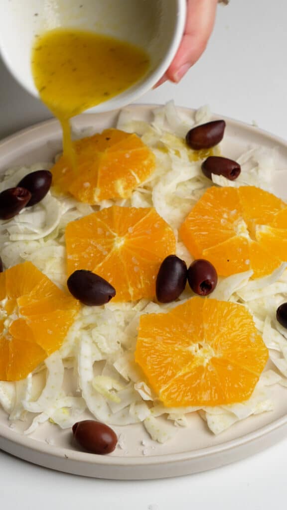 How to make Italian fennel salad (step 1) - top with oranges, olives, and dressing