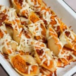 Butternut squash stuffed shells topped with mozzarella in a baking dish