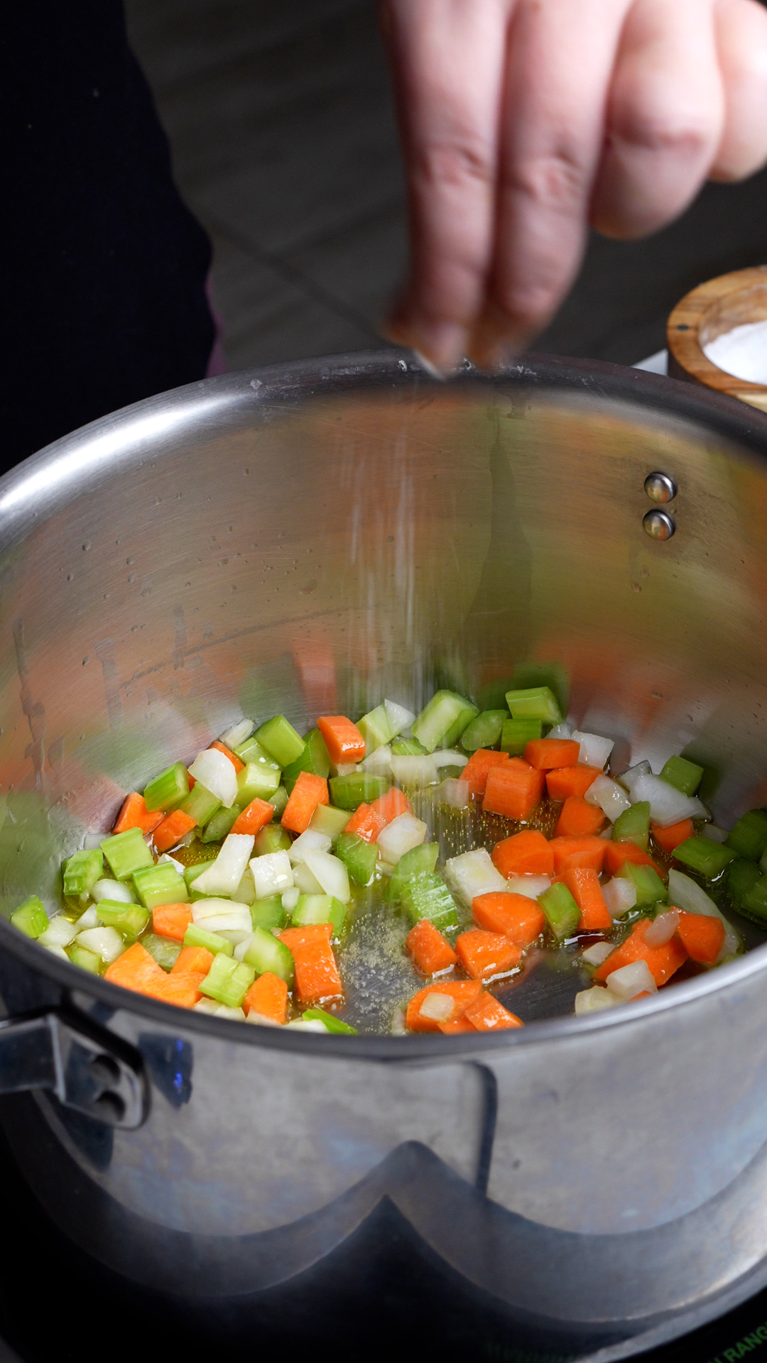 Step by step photos on how to make vegetarian rice soup - chopped carrots, celery and onion in a pot
