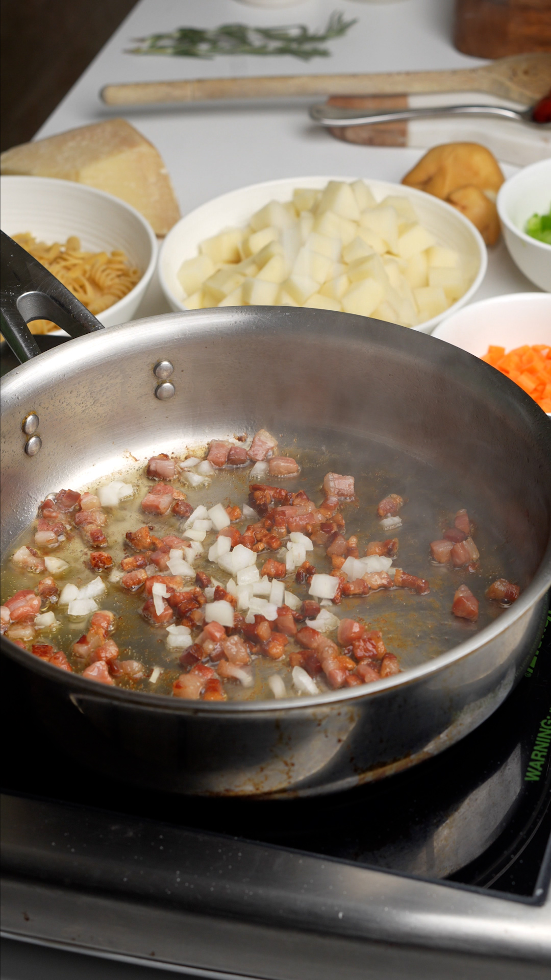 Pancetta sauteeing in pan with onion added