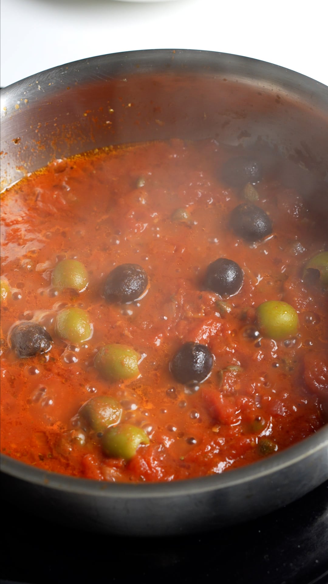 Step by step process on how to make vesuviana pasta - olives and capers in cooked tomato sauce